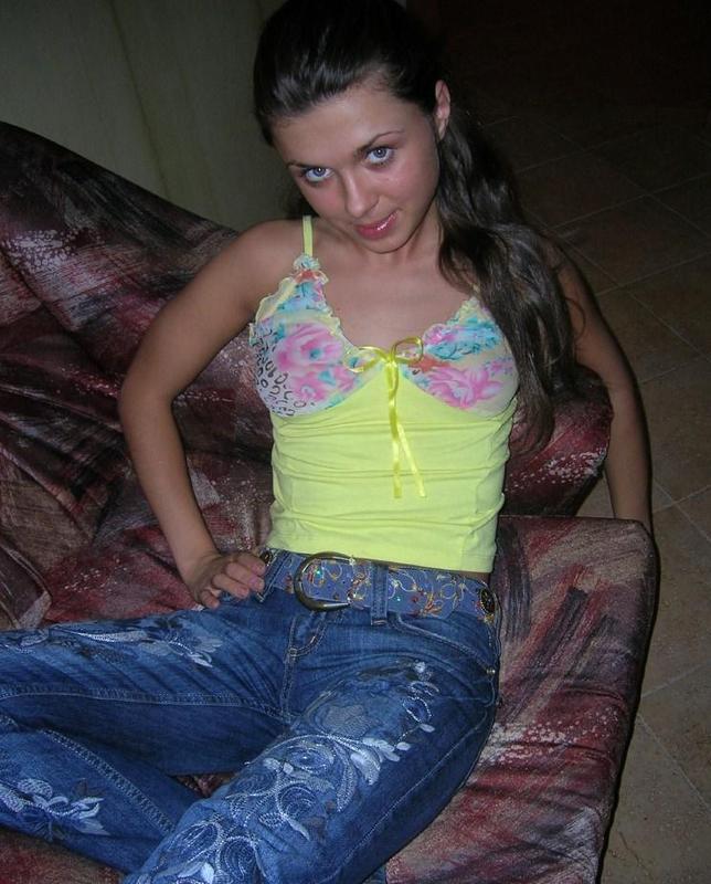 Сексуальная проститутка снимает с себя джинсы на кухне